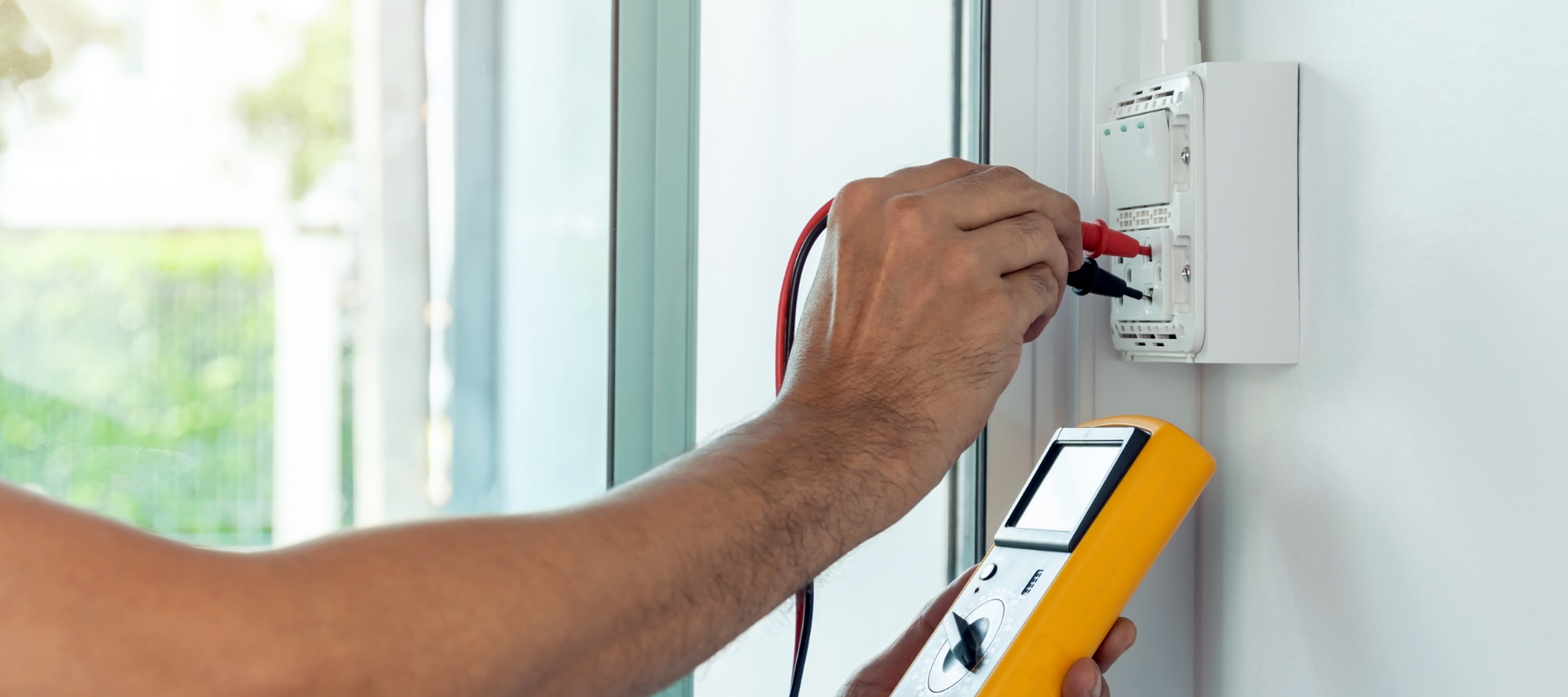 An electrician testing an outlet.